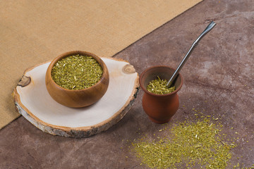 Close up South American yerba mate in calabash and in wooden bowl