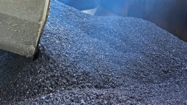 Truck Pouring Hot Asphalt into Asphalt Paver Machine - Zoom Out Shot