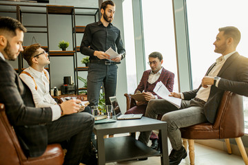 young caucasian successful business men hold meeting for making useful cooperation between companies, developing business strategies together in office