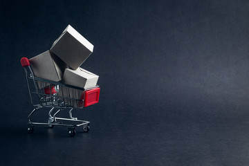 Shopping cart and box on dark background, business, shopping concept. Selective focus © instagram.com/_alfil