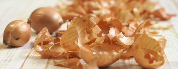 The use of onion skins in medicine and for coloring Easter eggs. Onion skin and onion on a wooden background.