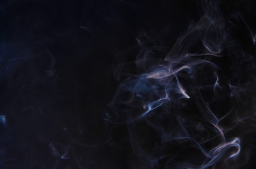 Obraz premium Abstract puffs of smoke on the left side of the frame on a dark background with a place for text, mysticism, fantasy