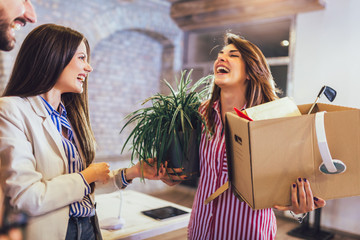 Woman having first working day getting in modern office, holding with his personal stuff.