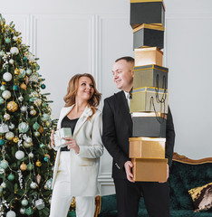 couple dressed in formal elegant costumes with gift boxes in their hands