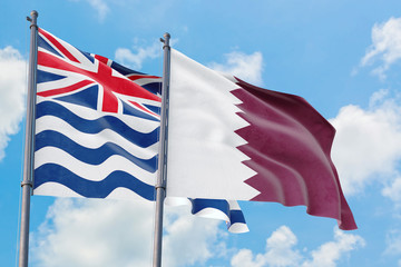 Qatar and British Indian Ocean Territory flags waving in the wind against white cloudy blue sky together. Diplomacy concept, international relations.