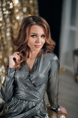 shiny woman in a silver dress on a gold background