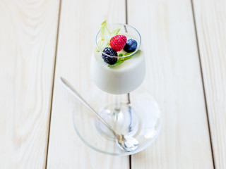 Delicious Italian Dessert Panna Cotta with Fresh Berries and Mint on Wooden Background