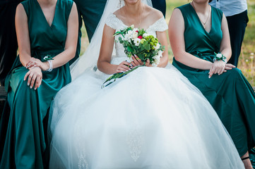 Bride and bridesmaid holding bouquet of flowers in the hand