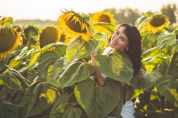 Beautiful young woman in a sunflower field. Portrait of a young woman in the sun. Pollen allergies...