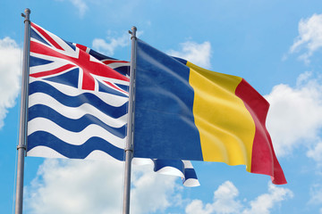Romania and British Indian Ocean Territory flags waving in the wind against white cloudy blue sky together. Diplomacy concept, international relations.
