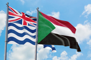Sudan and British Indian Ocean Territory flags waving in the wind against white cloudy blue sky together. Diplomacy concept, international relations.
