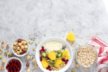 Healthy breakfast with yogurt, granola, fresh fruits and nuts on white background. Top view with copy space. Healthy eating.