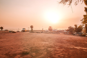 Pink sunset on beach.Purple Twilight.A gentle crimson sunset in a light sea haze.Soft purple color.the beach has palm trees,boats and bicycles for exploring the island.Holidays and travel in summer