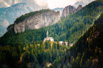 Small church with a chapel on a background of a mountain forest in the Italian Dolomite Alps, Italy. Wet glass photo style.