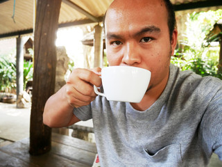 Asia man selfie and drinking hot coffee in the morning.