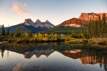 Scenery of Three sisters mountains reflection on pond at sunrise in autumn at Banff national park - obrazy, fototapety, plakaty