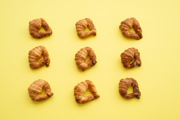 Homemade croissants on vibrant yellow background. Flat lay. 