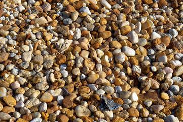 An assortment of smooth, mostly tan and white river stones form this background image.