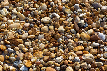 An assortment of smooth, mostly brown river stones form this background image.