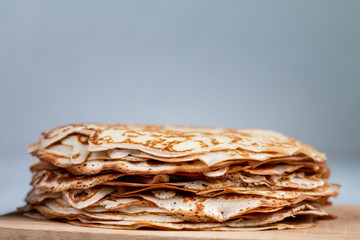 Stack of thin traditional delicious pancakes on a plate isolated with empty space for text, selective focus. Homemade family breakfast