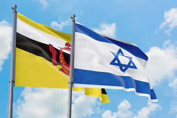 Israel and Brunei flags waving in the wind against white cloudy blue sky together. Diplomacy concept, international relations.