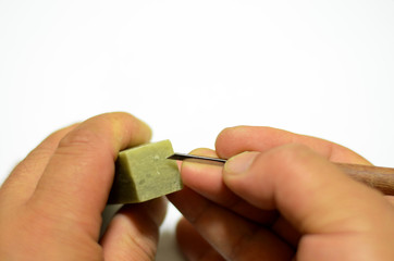 Men's hands carve seals on a white background