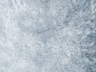 White and grey light woolen warm and fluffy carpet with soft texture fabric for elegant design in the interior and a cool wallpaper