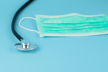 Stethoscope and Protective face mask on blue background, against Novel coronavirus (2019-nCoV) or Wuhan coronavirus and Influenza. Antiseptic, Hygiene and Healthcare concept