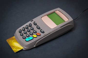Obraz premium Business still life payment terminal with card for receiving money on black office desk