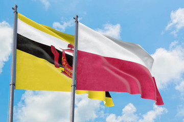 Poland and Brunei flags waving in the wind against white cloudy blue sky together. Diplomacy concept, international relations.