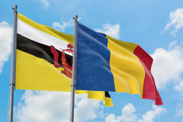Romania and Brunei flags waving in the wind against white cloudy blue sky together. Diplomacy concept, international relations.