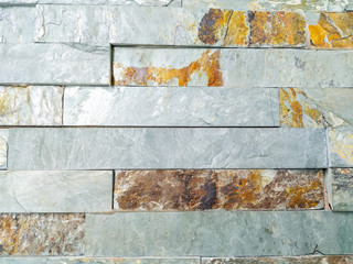 Modern looking stone rock tile bricks in grey color looking old and weathered on purpose for decorative effect with rust for interesting home interior design