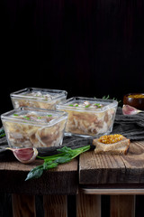 Holodets with chicken and pork meat in glass portion bowls against the dark background