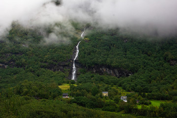 Waterfall in the forest mountains of Norway. Cloudy weather