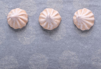 Meringues on the used baking parchment paper. Cooking background. Copy space
