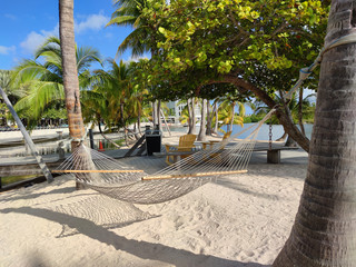 Hammock in sand island of Camana Bay. Camana Bay is a business, shopping and leisure complex in George Town of Grand Cayman Island