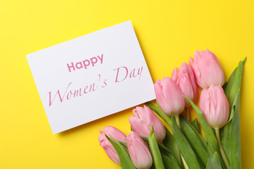 Pink tulips and inscription Happy women's day on yellow background, top view