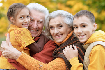 Fototapeta premium Happy grandfather, grandmother and grandchildren in park