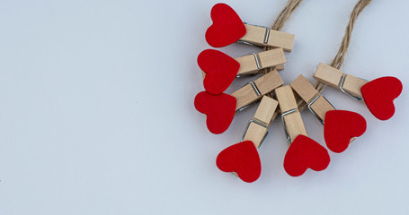 little red hearts on clothespins on a clean white sheet of paper
