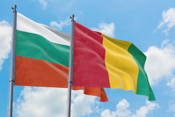 Guinea and Bulgaria flags waving in the wind against white cloudy blue sky together. Diplomacy concept, international relations.
