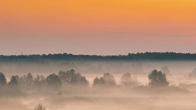 Amazing Sunrise Over Misty Landscape. Scenic View Of Foggy Morning Sky With Rising Sun Above Misty Forest And River. Early Summer Nature Of Eastern Europe. 4K