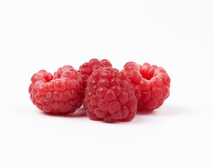 whole ripe red raspberries on a white background