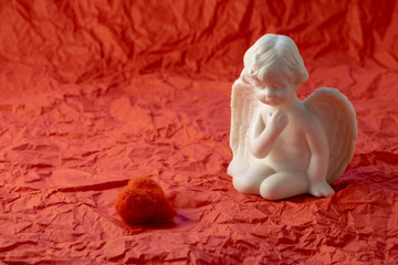 heart and sad angel on a red background