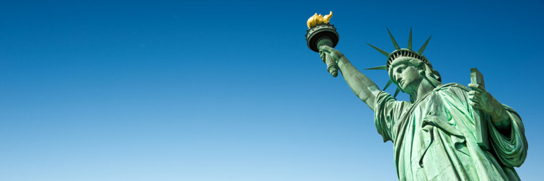 Statue of Liberty in New York, USA. Blue sky panoramic background with copy space