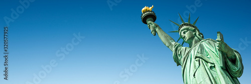Statue of Liberty in New York, USA. Blue sky panoramic background with copy space