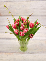 Tulips. Bouquet of flowers in vase, on wooden background. Springtime.