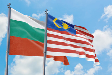 Malaysia and Bulgaria flags waving in the wind against white cloudy blue sky together. Diplomacy concept, international relations.