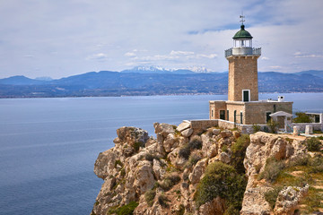 Melagkavi Lighthouse also known as Cape Ireon Light perching high on a headland overlooking eastern Gulf of Corinth, Greece. Bright sunny view of spring seascape, Cape Melagavi.