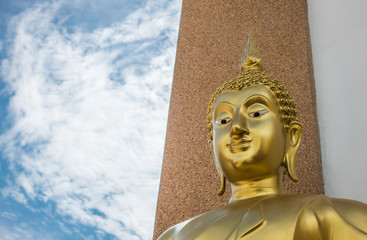 Fototapeta premium Close up the face of golden Buddha statue with the blue sky for peaceful concept and copyspace