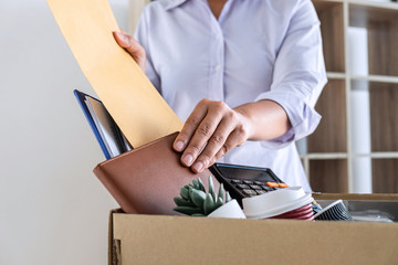 Images of stress of woman employee has a brown cardboard box and intend sending resignation letter to boss employer consider in order to contract for quit or layoff of job leaving from work - obrazy, fototapety, plakaty